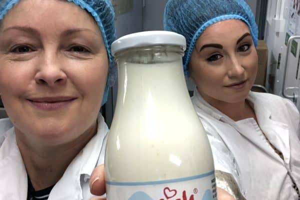Deborah is holding a flask of fermenting kefir grains in milk