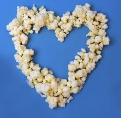 Real kefir grains in shape of a heart on a blue background